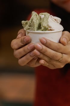Close up hand of a person holding a cup of ice cream with blurred background photo