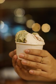 Close up hand of a person holding a cup of ice cream with blurred background photo