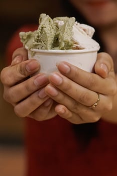 Close up hand of a person holding a cup of ice cream with blurred background photo
