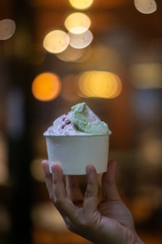Close up hand of a person holding a cup of ice cream with blurred background photo