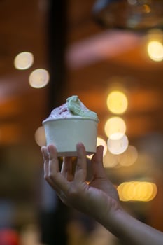 Close up hand of a person holding a cup of ice cream with blurred background photo