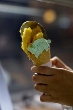 Close up hand of a person holding a cone of ice cream with blurred background photo
