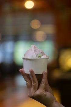 Close up hand of a person holding a cup of ice cream with blurred background photo