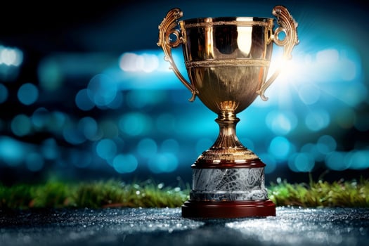the gold cup for the first place on the background of a football field. The golden trophy of the champion. A sporting victory, a prize for the winner. photo