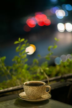 A cup of hot coffee on the table outdoor at night photo