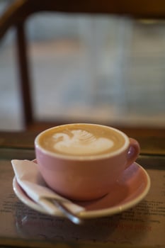 A cup of coffee latte with froth art on the table photo