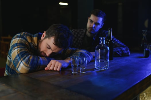 Drunk man sleeps at bar counter, alcohol addiction photo