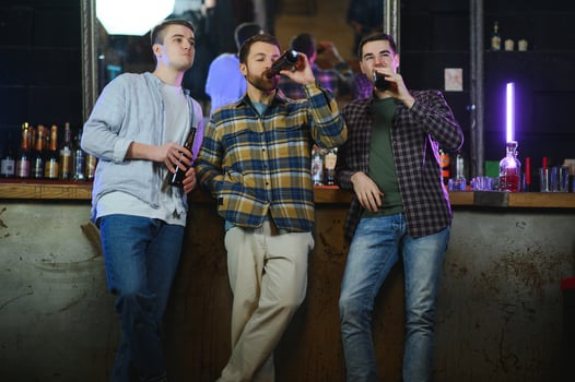 Friends having fun. Happy young men in casual wear drinking beer in pub. photo