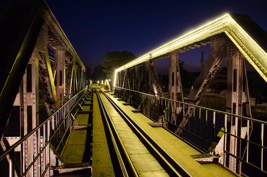 famous Railway bridge with yellow neon lamp at Kanchanaburi, Thailand with slective focus photo