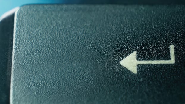 Close-Up of an Arrow Key on a Computer Keyboard Against a Soft Blue Background photo