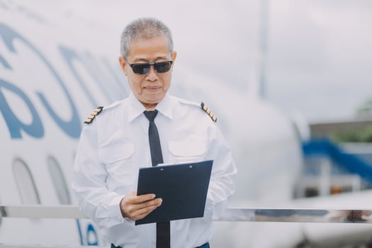 Professional pilot woman in uniform has teamwork meeting for success flight in aviation business. Young female captain instructor sitting in office and working or training commercial airline crew. photo