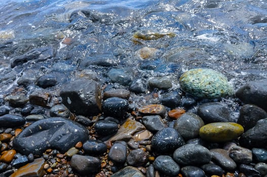 Kara-Dag, a round sea-rolled pebble from a volcanic rock on a pebble beach, Crimea photo
