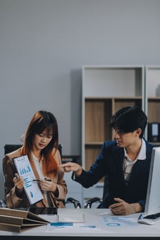 Entrepreneur Asian businessman and businesswoman discussing new business project in tablet in modern Meeting In Modern Office, Asian business casual concept. photo