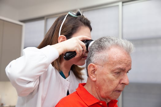 Dermatologist performing a trichoscopy to a senior male patient. photo