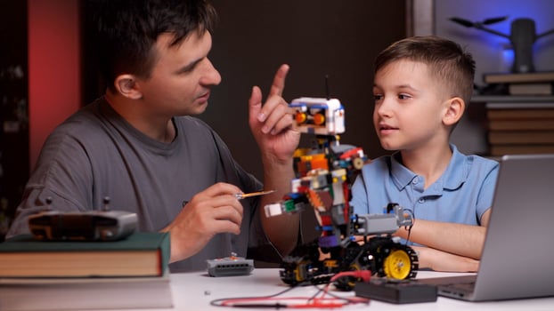 Father and son building robot and developing robotics skills photo