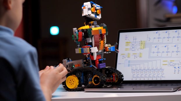 Child programming robot using laptop in high tech computer class photo