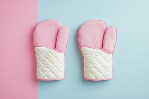 Pink and White Quilted Oven Mitts on Pastel Blue and Pink Background - Kitchen Essentials photo