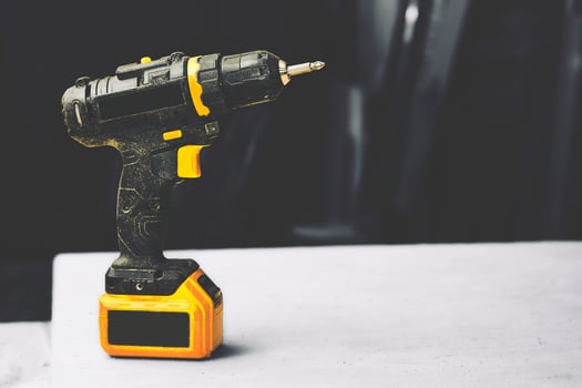 Electric drill, screwdriver on a black white workshop photo