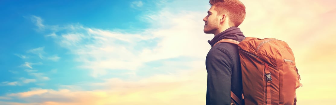 High school boy gazing at the sky during sunset with backpack photo