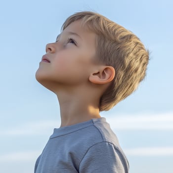 High school boy gazing thoughtfully at the clear blue sky outdoors photo