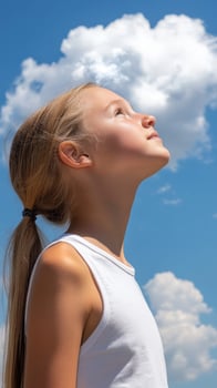 High school girl gazing at fluffy clouds in a blue sky photo