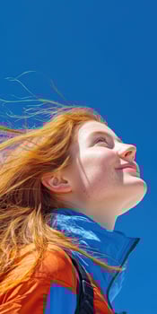 High school girl smiling while gazing at the clear blue sky outdoors photo