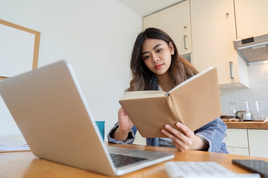 Woman Working from Home in Dining Room with Laptop and Notebook, Remote Work Concept, Modern Home Office Setup photo