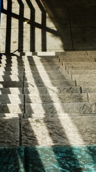 Abstract background texture of a staircase with a geometric shadow cast on it. The shadow is on the steps and the steps are grey photo