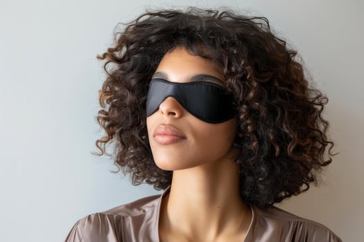 Serene young woman wearing a sleep mask relaxing photo
