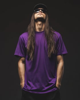 Model displays a blank t-shirt with confidence in a moody setting photo