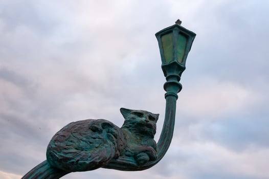 UKRAINE, ODESSA - DECEMBER 25, 2018 the cat sits on a crooked street lamp, a sculptural composition made of metal, Odessa photo