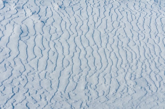 Weathered ice and frozen snow in the form of needle crystals on the bank of the Tiligul Estuary on a sunny day photo