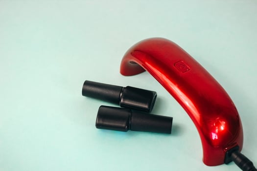 UV lamp and gel nail polish. manicure flat on a turquoise background photo