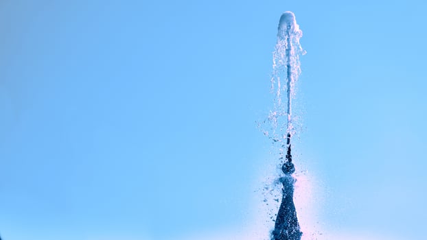 Fountain with shining clear liquid on a sky background photo