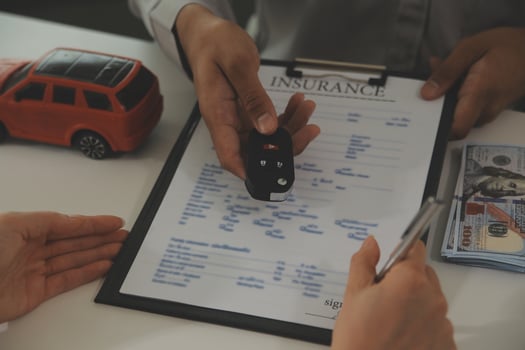 Young man receives a key from car salesman. After agreeing to a contract for rent or sale of a car at workshop, loan car, insurance, sale, buying car and finance concept. photo