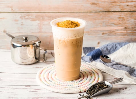 Iced Wheat Germ Milk Tea with sugar pot and spoon served in disposable glass isolated on table side view of hong kong tea photo