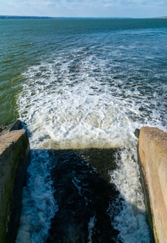 Waste water is poured into the estuary, dirty foam. Ecological problems of the reservoir. Hadzhibey estuary, Ukraine photo