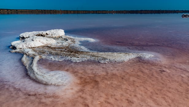 Salt Lake. Self-settling sodium chloride salt on rocks near the shore. Hypersaline water photo