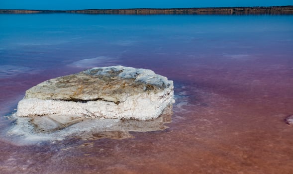 Salt Lake. Self-settling sodium chloride salt on rocks near the shore. Hypersaline water photo