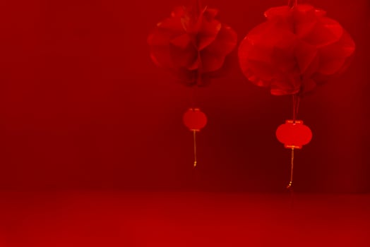 Two paper Chinese lanterns on a bright red background. Close up. Chinese Lunar New Year celebration concept. photo