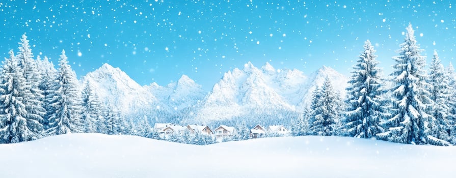 A serene winter landscape featuring snow-covered mountains and evergreen trees under a clear blue sky with falling snowflakes. photo