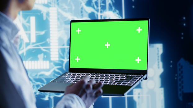 Computer scientist using chroma key laptop to write artificial intelligence script code in startup workplace. Dilligent worker doing maintenance work in data center, updating AI systems photo