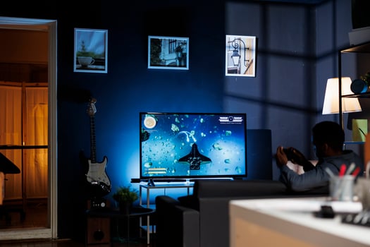 Online gamer enjoying shooter gaming competition at home, participating in multiplayer shooting tournament with friends at night. Young player having fun with games championship. photo