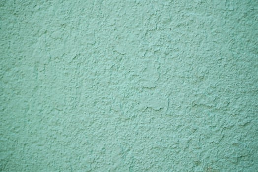 An aesthetically pleasing textured mint green wall surface featuring subtle, intricate patterns photo