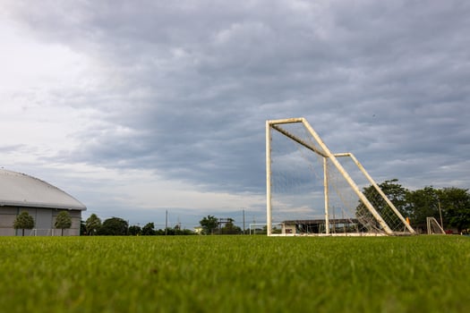 Low angle view of an old white metal soccer goal installed on a grass field. photo