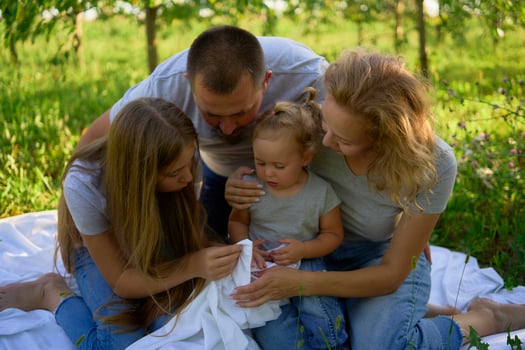 a family of four on a picnic in the park photo