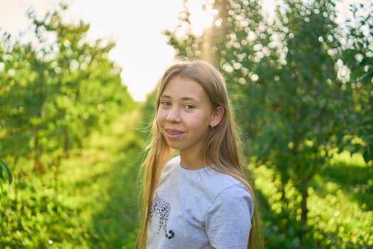 a portrait of a teenage girl with long blond hair in a sunlit garden photo