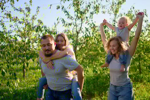 parents ride their children on their backs photo
