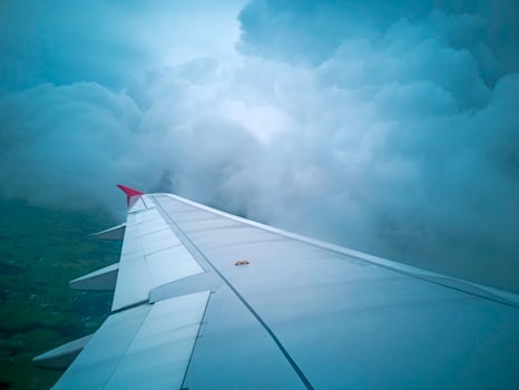 wings of airplane during the flight look from the passenger window. There are white clouds in the blue sky. photo