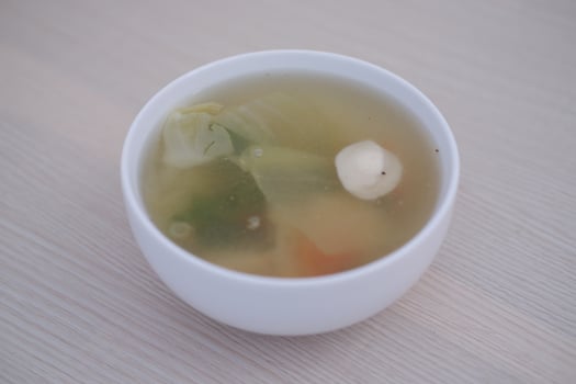 A bowl of soup on a wooden table photo